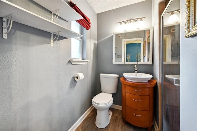 bathroom with vanity, hardwood / wood-style flooring, toilet, and a textured ceiling