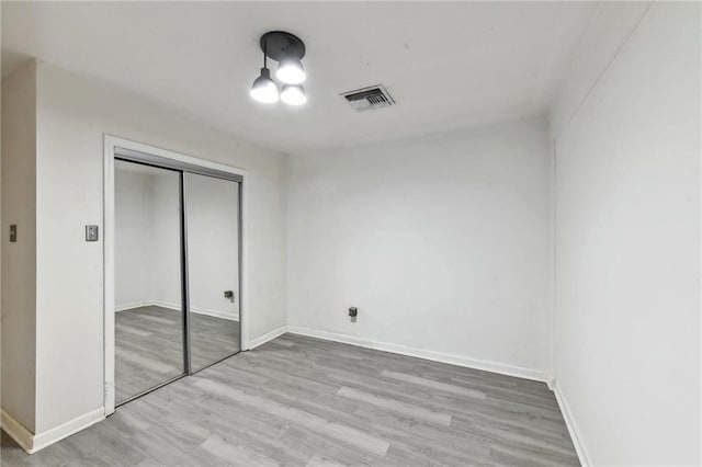 unfurnished bedroom featuring light wood-type flooring and a closet