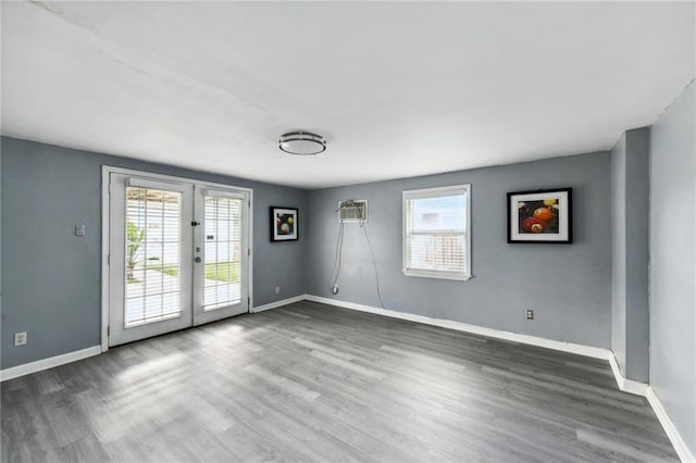 unfurnished room with french doors, dark wood-type flooring, and a wall unit AC