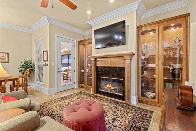 living room with ornamental molding, ceiling fan, light tile patterned floors, and a fireplace