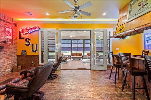 interior space with ceiling fan and crown molding