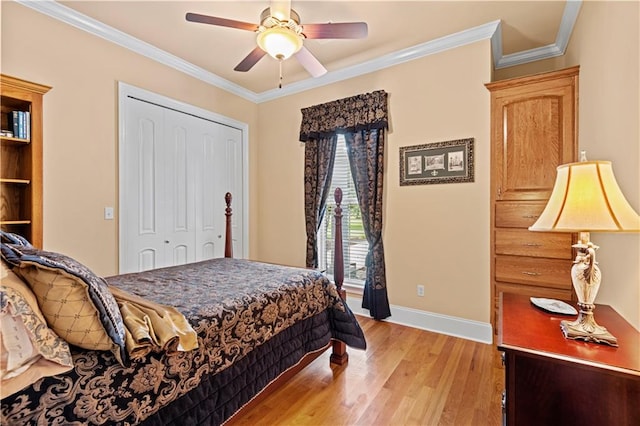 bedroom featuring light wood-type flooring, ornamental molding, ceiling fan, and a closet