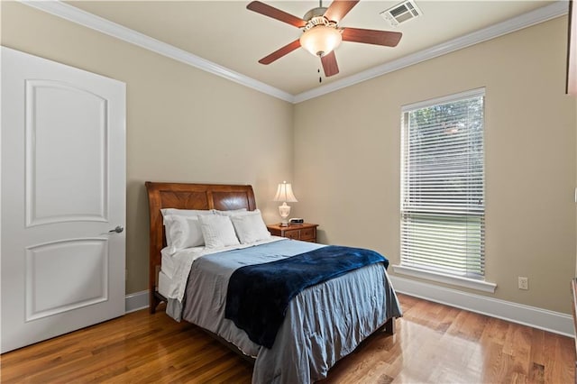 bedroom featuring ceiling fan, crown molding, and hardwood / wood-style floors