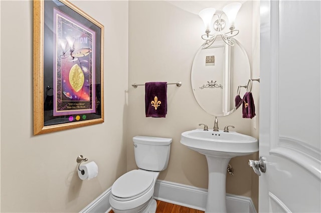 bathroom featuring wood-type flooring and toilet