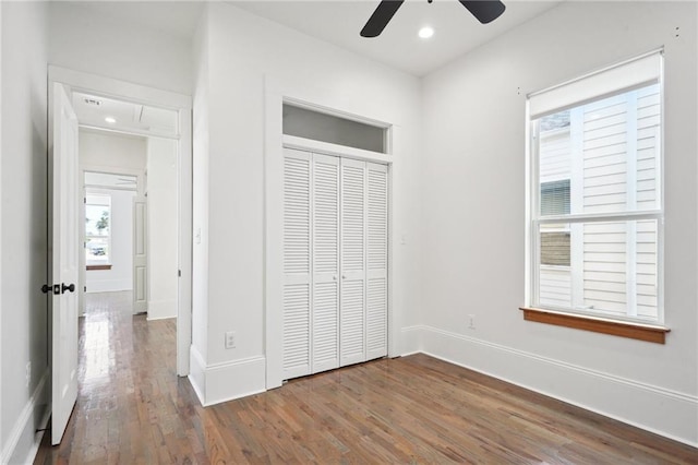 unfurnished bedroom with hardwood / wood-style floors, ceiling fan, and a closet