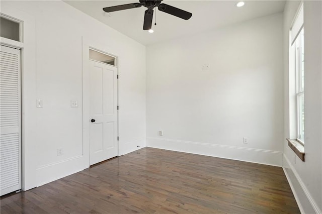 unfurnished bedroom featuring dark wood-type flooring, ceiling fan, and a closet