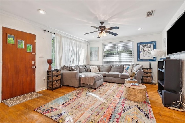 living room featuring ornamental molding, hardwood / wood-style flooring, and ceiling fan