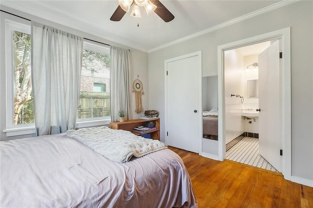 bedroom with ceiling fan, hardwood / wood-style flooring, ornamental molding, ensuite bathroom, and sink