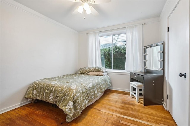 bedroom with ceiling fan, crown molding, and light hardwood / wood-style floors