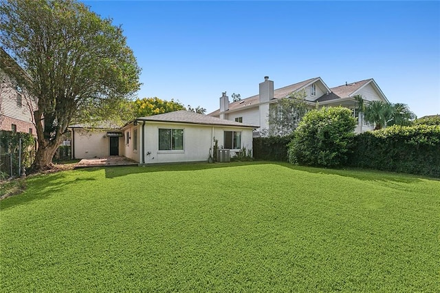 back of house featuring cooling unit and a lawn