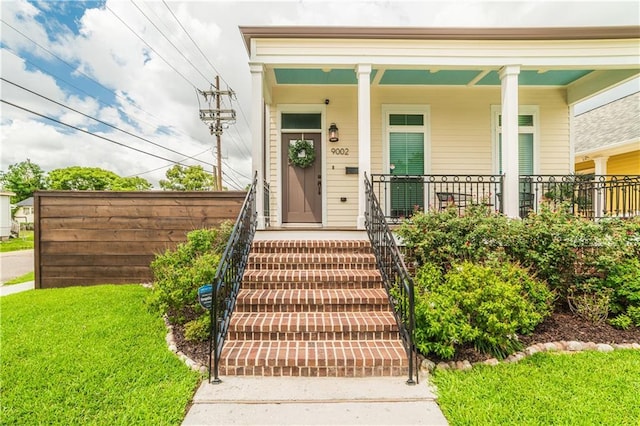 9002 Colapissa St, New Orleans, LA 70118 - entrance to property featuring covered porch and a yard