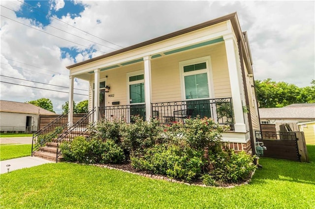 9002 Colapissa St, New Orleans, LA 70118 - shotgun-style home featuring a porch and a front yard
