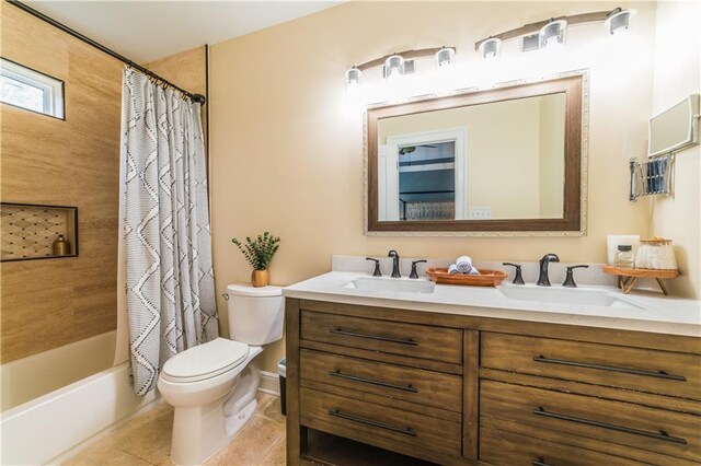 full bathroom featuring tile patterned flooring, vanity, toilet, and shower / bathtub combination with curtain