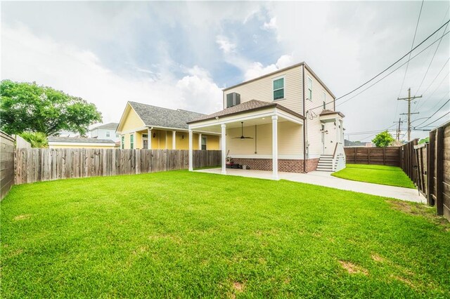 back of property featuring a yard, ceiling fan, and a patio area