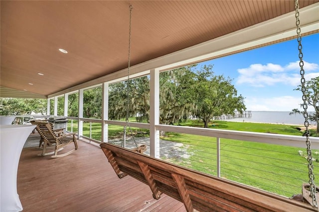 sunroom featuring plenty of natural light and a water view