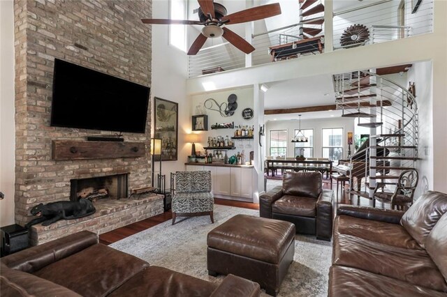 115 Holly St, Mandeville, LA 70448 - living area with high vaulted ceiling, a ceiling fan, plenty of natural light, wood finished floors, and a fireplace
