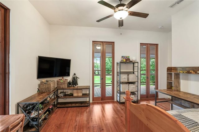 living room featuring a wealth of natural light, visible vents, wood finished floors, and french doors