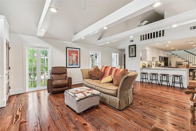 living area featuring visible vents, wood finished floors, vaulted ceiling with beams, stairs, and recessed lighting