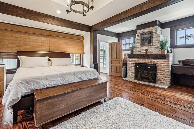 115 Holly St, Mandeville, LA 70448 - bedroom featuring wood finished floors, multiple windows, a chandelier, a fireplace, and recessed lighting