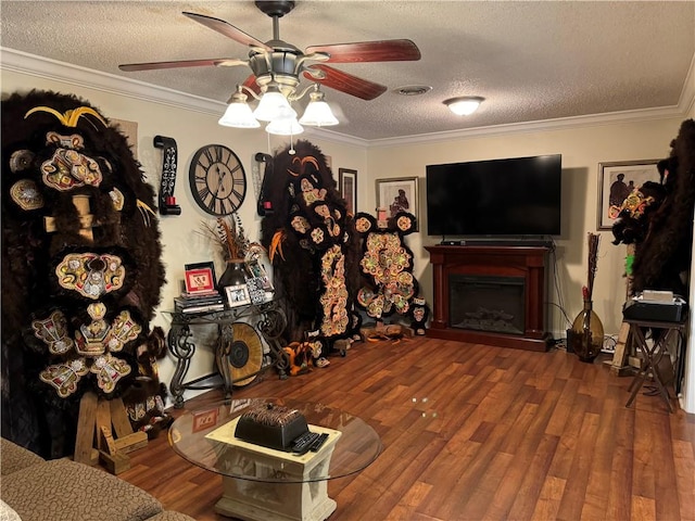 living room featuring a textured ceiling, hardwood / wood-style flooring, ceiling fan, and crown molding