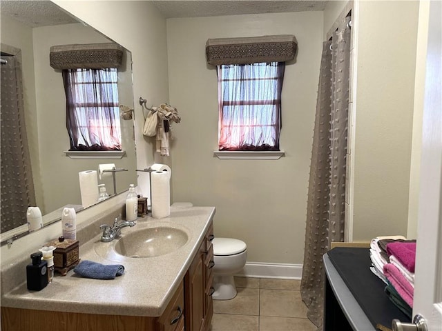 bathroom with vanity, tile patterned flooring, toilet, and a textured ceiling