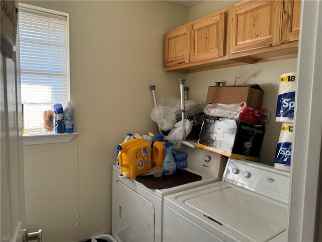 clothes washing area with cabinets and washer and dryer