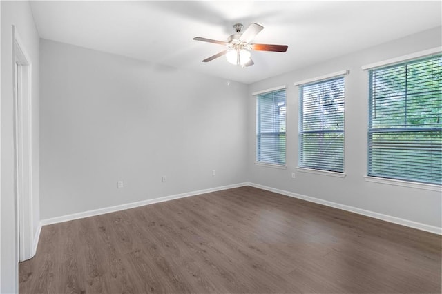 spare room with ceiling fan and dark hardwood / wood-style flooring