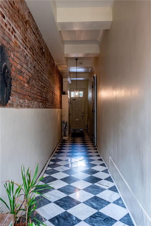 corridor featuring brick wall