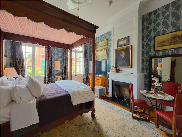 bedroom featuring multiple windows, wood-type flooring, and ornamental molding