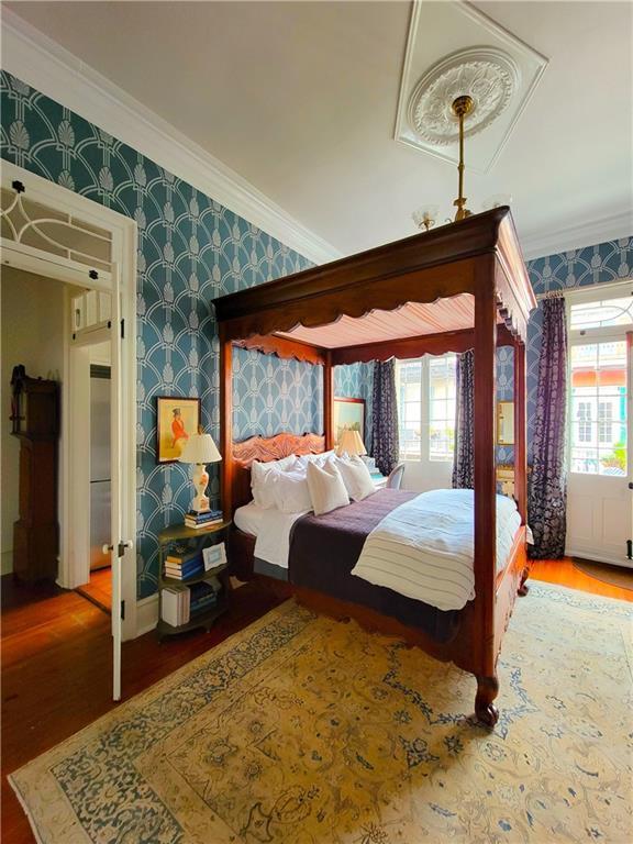 bedroom with hardwood / wood-style flooring and crown molding