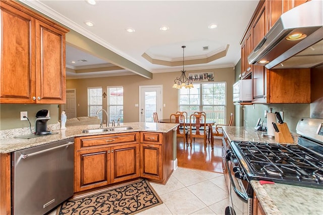 kitchen with appliances with stainless steel finishes, sink, a healthy amount of sunlight, and extractor fan