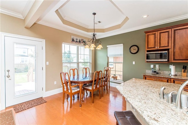 dining area with a notable chandelier, light hardwood / wood-style flooring, and ornamental molding