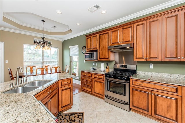 324 38th St, New Orleans, LA 70124 - kitchen with appliances with stainless steel finishes, under cabinet range hood, a sink, brown cabinets, and a chandelier