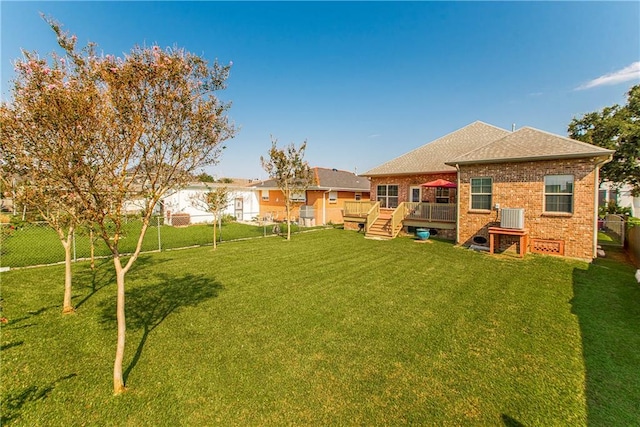 view of yard featuring a deck and central air condition unit