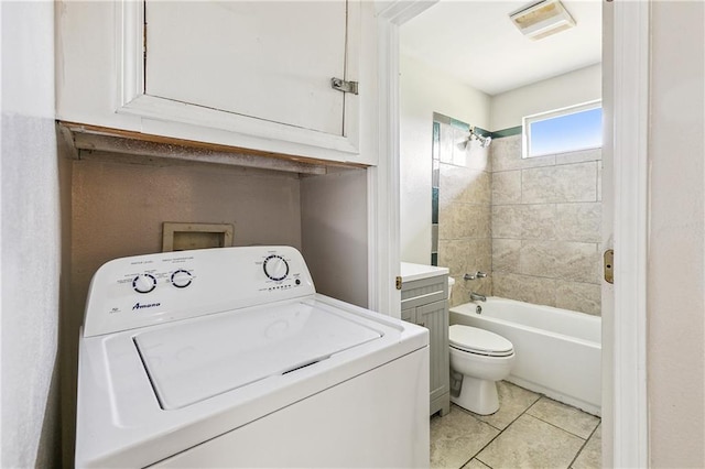 interior space featuring vanity, tiled shower / bath combo, tile patterned flooring, washer / clothes dryer, and toilet