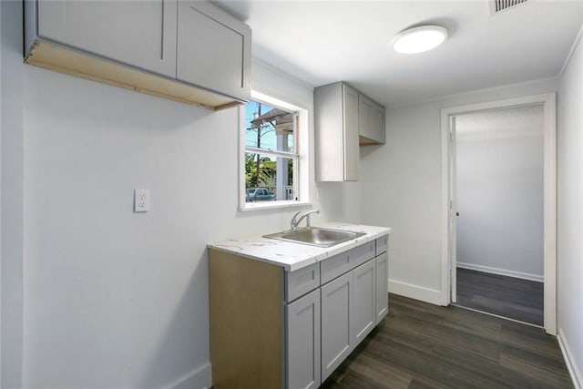 2252 N Villere St, New Orleans, LA 70117 - kitchen featuring gray cabinetry, baseboards, a sink, dark wood-type flooring, and light countertops