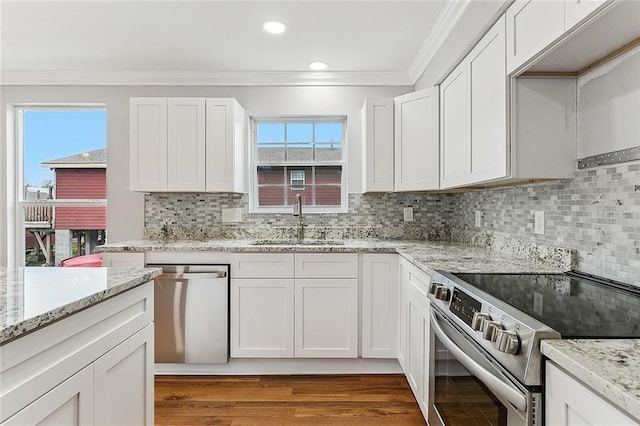 kitchen with plenty of natural light, white cabinetry, sink, and appliances with stainless steel finishes