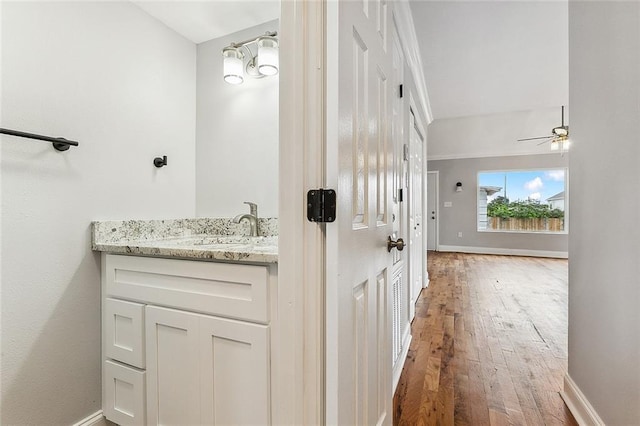 bathroom featuring ceiling fan, hardwood / wood-style floors, and vanity