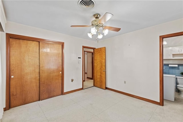 unfurnished bedroom with ceiling fan, a closet, and connected bathroom