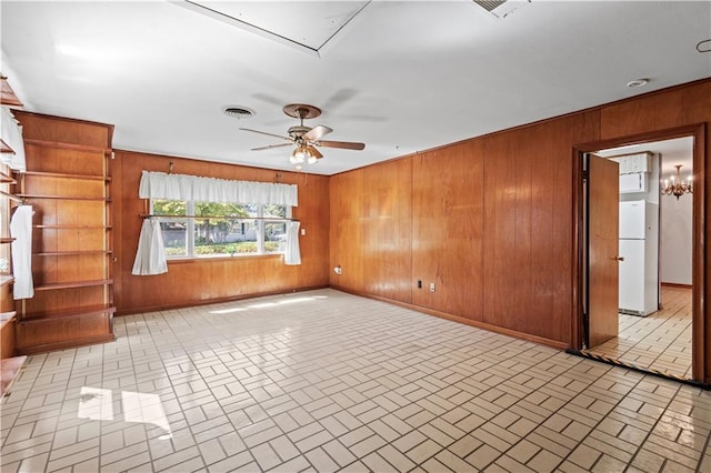 unfurnished living room with wood walls and ceiling fan