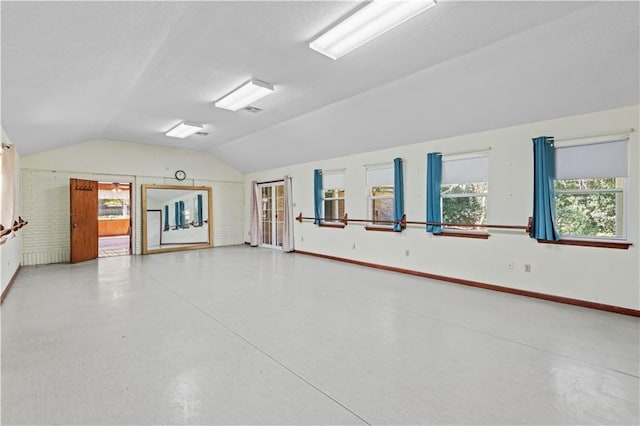 empty room featuring vaulted ceiling and concrete floors