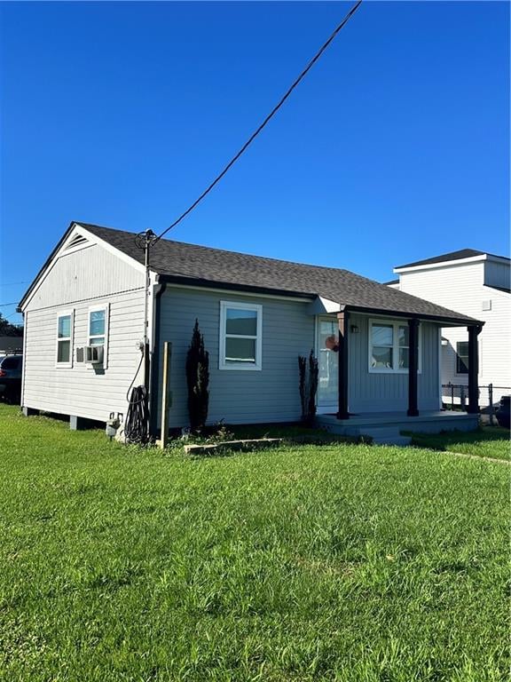 back of house featuring a porch, a yard, and cooling unit