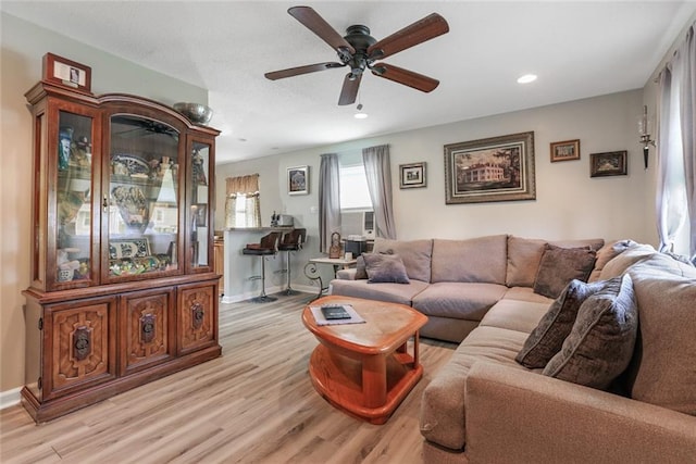 living room with ceiling fan and light wood-type flooring