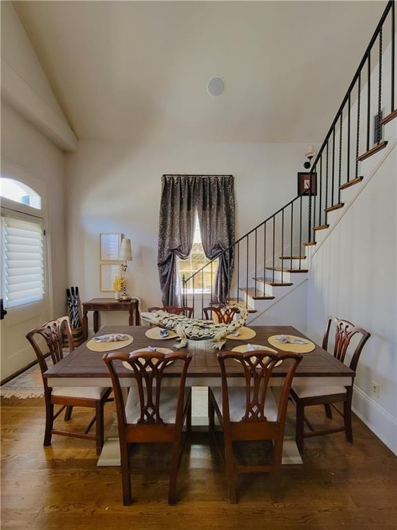 dining space featuring lofted ceiling and dark hardwood / wood-style floors