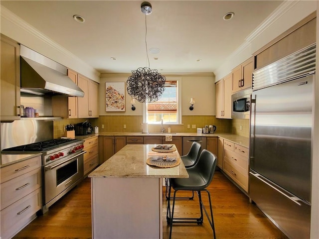 kitchen with dark hardwood / wood-style floors, a kitchen island, high end appliances, and wall chimney exhaust hood