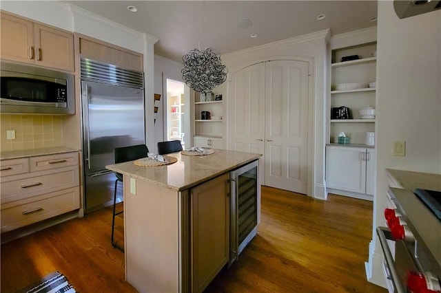 kitchen featuring a center island, backsplash, built in appliances, dark hardwood / wood-style floors, and beverage cooler