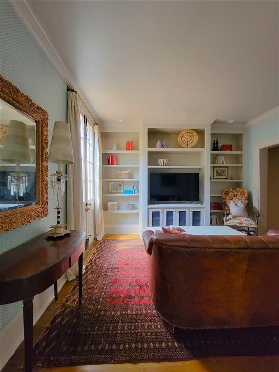 living room featuring crown molding and built in features