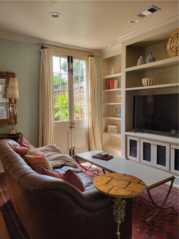 living room with built in shelves and crown molding