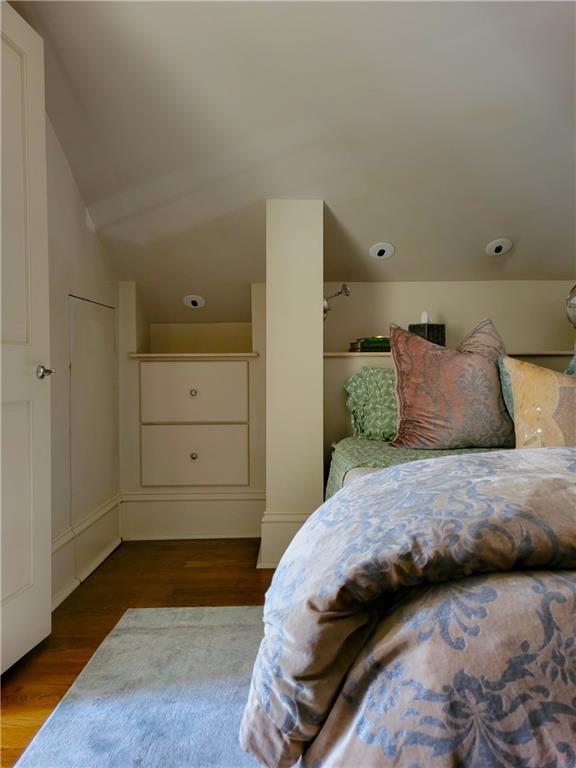 bedroom with vaulted ceiling and dark hardwood / wood-style floors