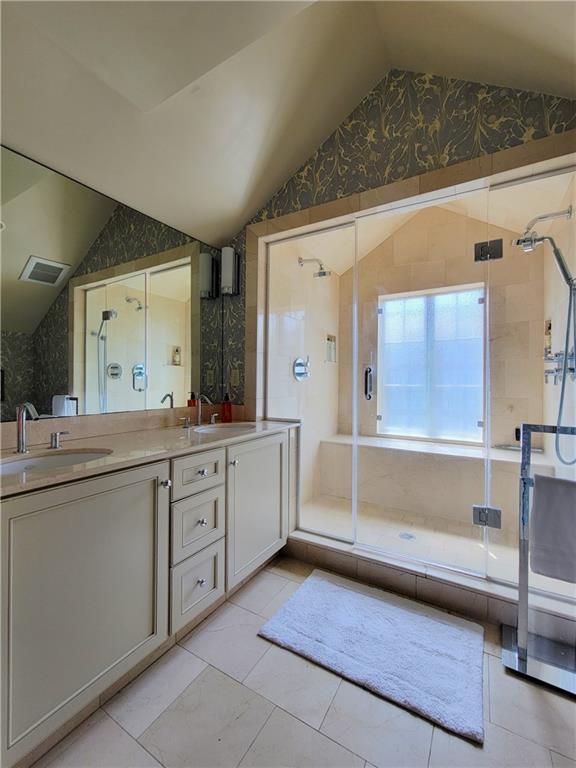 bathroom featuring tile patterned floors, vanity, an enclosed shower, and vaulted ceiling